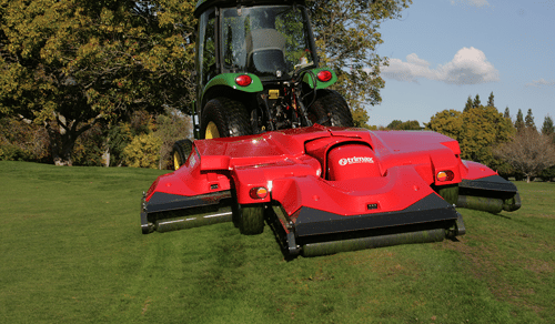 Red Lawn Mower Attached to Green Tractor | About Trimax Mowing Systems